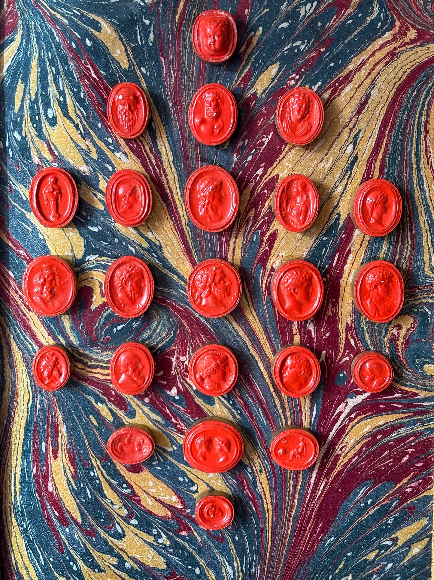Set of early 19th-century Grand Tour intaglios, cast in plaster and painted in vivid vermilion.
